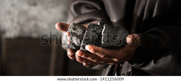Coal\
mining : coal miner in the man hands of coal background. Picture\
idea about coal mining or energy source, environment protection.\
Industrial coals. Volcanic rock. Panorama\
photo
