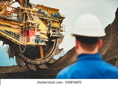 Coal mining in an open pit. Miner looking on the huge excavator. Industry in the Czech Republic, Europe