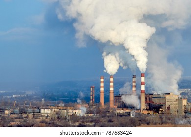 Coal power plant smokestacks emit carbon dioxide pollution by factory under blue sky. environmental pollution