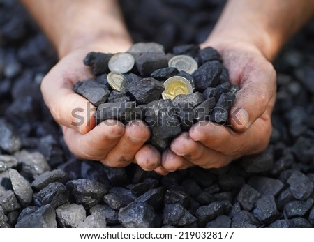 Coal prices. Coal and coins in coal miner hands. Heating.Money and coal. Górnictwo węgla. Pieniadze, ceny węgla, biznes. Przemysł węglowy wydobycia węgla ogrzewanie, źródła energii. Ochrona środowiska
