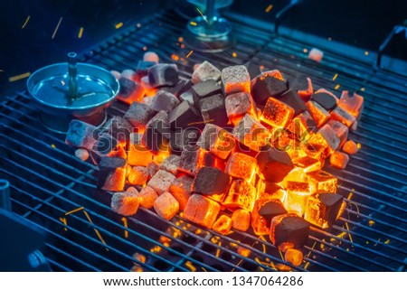 Coals for hookah. On the grill burn coals. Accessories for hookah. Coal ignition Coconut coal. Restaurant with hookahs.