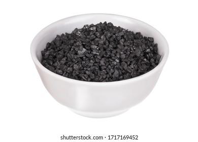 Coarse black salt in a bowl isolated on a white background. Hawaiian lava salt. Himalayan black rock salt. Thursday's salt.