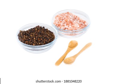 Coarse pink salt and peppercorn in glass bowls with two wooden spoons on white background. - Powered by Shutterstock