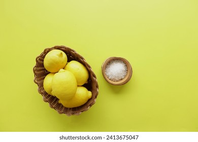 Coarse salt in a bowl and lemon on yellow background  - Powered by Shutterstock