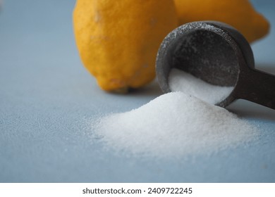 Coarse salt in a spoon and lemon on black background  - Powered by Shutterstock