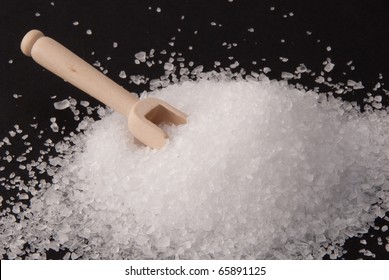 Coarse-grained sea salt from the Atlantic with a wooden scoop on black background - Shutterstock ID 65891125