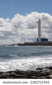 Coast of Atlantic ocean with light waves at the coastline. View on industrial zone with a white high lighthouse. Capital city Puerto del Rosario, Fuerteventura, Spain. - Shutterstock ID 2282721965
