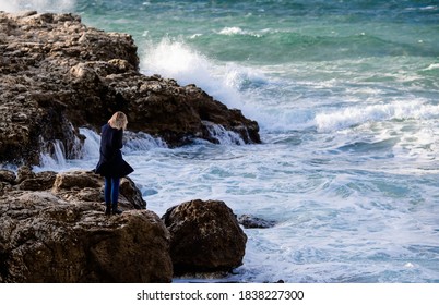 coast of Crimea.Tourist girl on the edge of a cliff. Element. Danger. Huge wave. Vacation and tourism concept. - Powered by Shutterstock