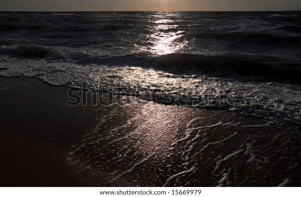 Coast and\
night moonlight path on sea water\
surface