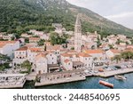 Coast of Perast with ancient stone houses and the bell tower of the Church of St. Nicholas. Montenegro. Drone