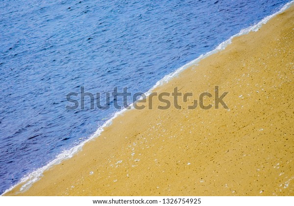 Coast of the sea,\
divided in half diagonally with water and sand. Background of sea\
water and sand