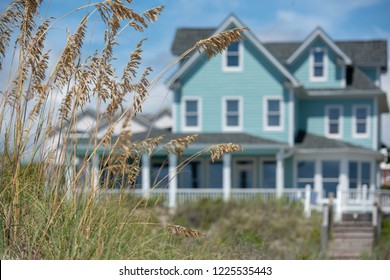 Coastal Beach House In A Pastel Teal Color With Plants And Ocean