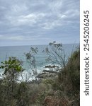 Coastal bush walk at Point Arkwright watching storm clouds rolling in with strong waves hitting the rocky reef near Coolum Beach Sunshine Coast Queensland Australia. Many tourists walk the coastal tra