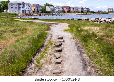 Coastal gravel road with the small seaside neighborhood on the background in East Greenwich, Rhode Island