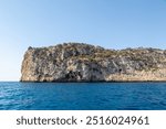 Coastal landscape image of the cliffs along the Spanish coastline from a boat, Image shows a beautiful scenic photo of the cliffs with blue skies and blue sea 