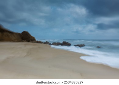 coastal landscape with a sandy beach stretching along the shoreline. The left side of the image showcases tall, golden cliffs with distinct layers of rock formations - Powered by Shutterstock