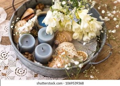 Coastal Or Rustic Interior Design Concept. Table Centerpiece With Metal Tray Filled With Candles, Seashells And Flowers.