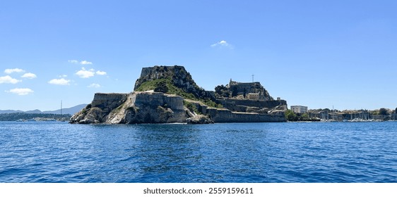 Coastal view of Corfu Fortress on Corfu Island, Greece. Ancient stone fortress atop rocky hill surrounded by blue Ionian Sea. Clear sky, historical architecture, and lush greenery. - Powered by Shutterstock