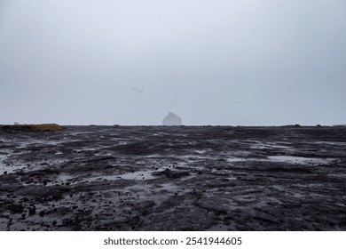 Coastal Volcanic Ocean Cliffside in Iceland on a Rainy and Foggy Day with a House Slightly Obscured by the Fog. High quality photo - Powered by Shutterstock