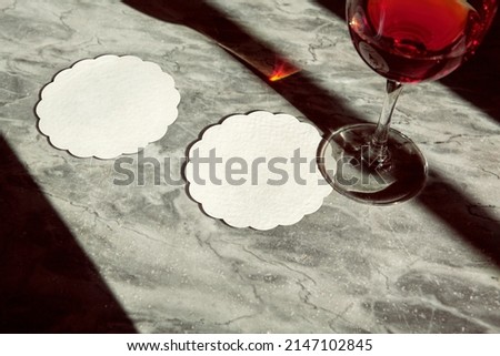 Coasters thin white scallop shape with wine glass under sunlight