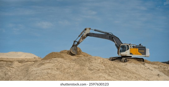 Coastline construction activity involves heavy machinery moving sand on a sunny day for erosion prevention at a coastal site