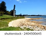 Coastline in Kurnell, NSW, on the edge of Botany Bay National Park, with a white spire marking the spot where James Cook first landed in Australia in 1770.