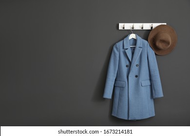 Coat And Hat On Wall Hanger In Stylish Hallway Interior. Space For Text