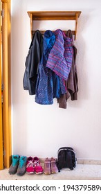 Coat Rack Full Of Clothes Of The Members Of A Family: Jackets, Shoes And Backpack. Family Everyday Life Concept. World Family Day