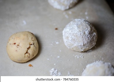 Coating Mexican Wedding Cakes With Powdered Sugar.