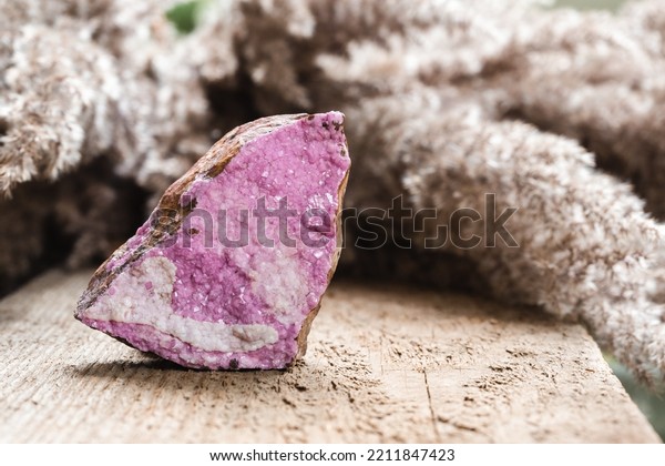 Cobaltoan\
Calcite Pink Crystals Cluster. Spherocobaltite Cobalt Carbonate\
Mineral Stone over Natural Wooden\
Background