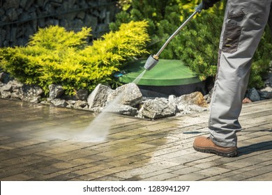 Cobble Brick Driveway Pressure Washing By Worker.