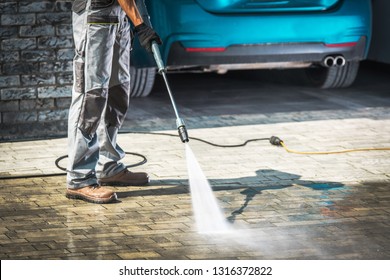 Cobble Driveway Pressure Washing by Caucasian Worker.