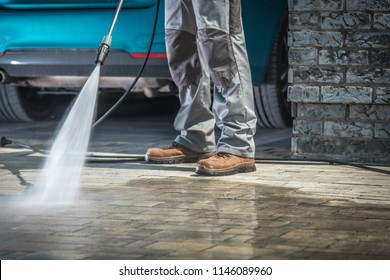 Cobble Stone Driveway Cleaning Using Pressure Washer With Concrete Cleaning Detergent. Closeup Photo.