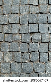 Cobbled granite pavement background, regular shapes of cobbled stone path, abstract background of old cobblestone pavement.Roads in historic old urban areas. 