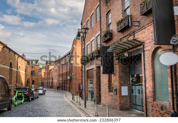 Cobbled\
Street Lined with Renovated Brick\
Buildings