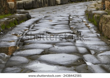 Cobbled streets of the city of Pompeii. Wet streets and cloudy skies. Ancient Roman city buried after the eruption of the Vesuvius volcano in 79AD