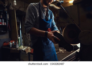 Cobbler in apron is working on shoe using special machine at his workshop. - Shutterstock ID 1543282487