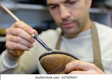 cobbler gluing a shoe - Powered by Shutterstock