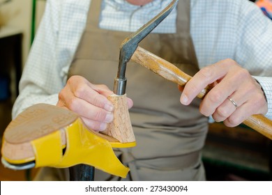 Cobbler hammering a shoe - Powered by Shutterstock