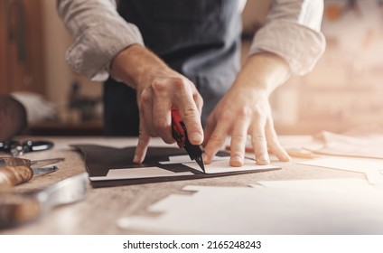Cobbler Man tailor cuts out blanks for sewing bags or shoes according to pattern made of leather. - Shutterstock ID 2165248243
