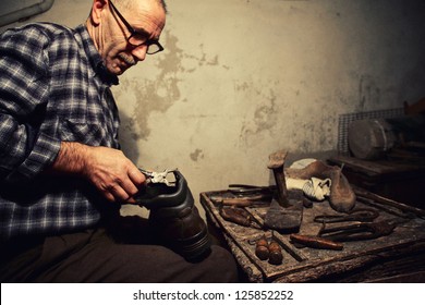 cobbler at work with old tools - Powered by Shutterstock