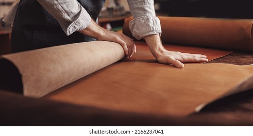Cobbler working with skin textile in workshop. Tailor hold different rolls natural brown leather. - Powered by Shutterstock
