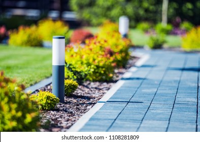 Cobblestone Brick Path In The Garden With Elegant And Modern LED Lighting.