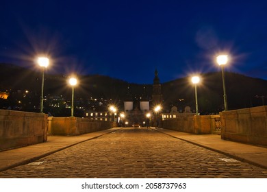 A cobblestone bridge illuminated at night