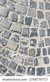 Cobblestone pavement features a textured surface constructed from irregular granite setts