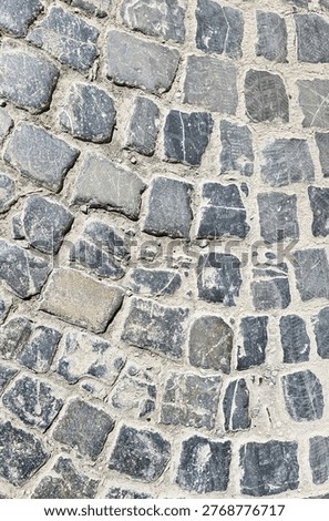 Cobblestone pavement features a textured surface constructed from irregular granite setts