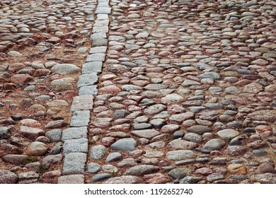Cobblestone road. Large stones on road. Background from big stones. Road surface. Texture of stones. Selective focus.