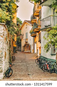 Cobblestoned Street With Bicycles At Romantic Luxury Resort In Ascona Town On Lake Maggiore Of Ticino Canton In Switzerland. Outdoor Expensive Family Travel In Swiss City In Summer. Italian Holiday