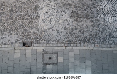 Cobblestones and sidewalk seen from above.