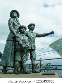 COBH, IRELAND – AUGUST 20, 2018: The Famous Statue Of 17-year-old Annie Moore And Her Brothers Looking Out Onto The Harbor Commemorates The First Immigrants Processed At Ellis Island In 1892.